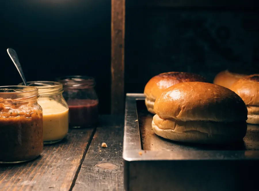 Buns briochés dorés à la plancha à côté des pots de sauces maison